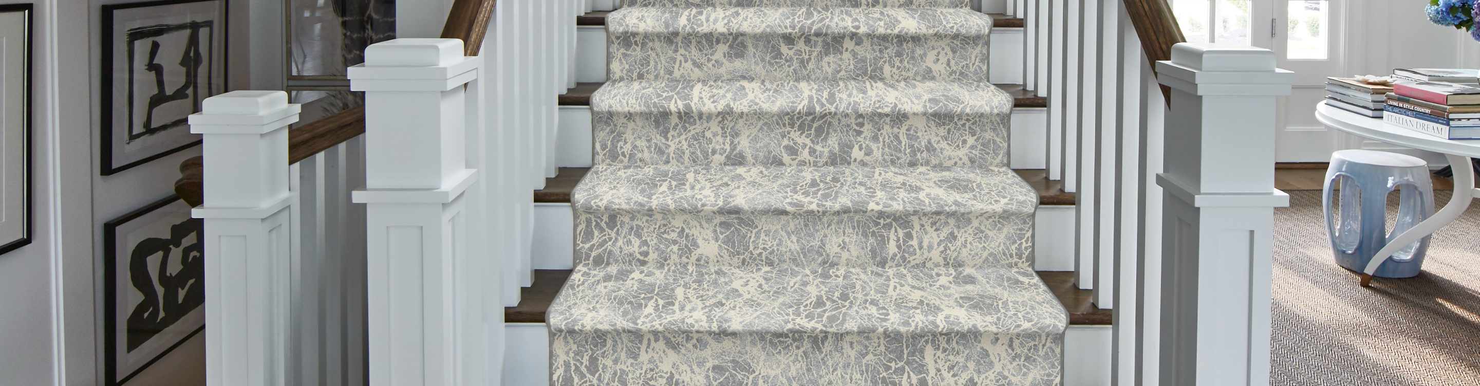 Patterned carpet stair runner on hardwood stairs. 
